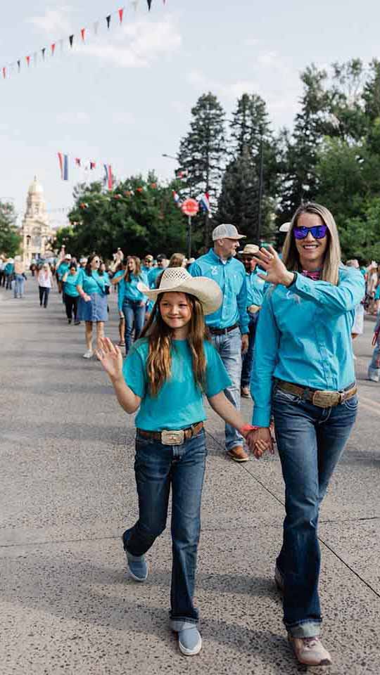 Lauren and her daughter walking in a parade.
